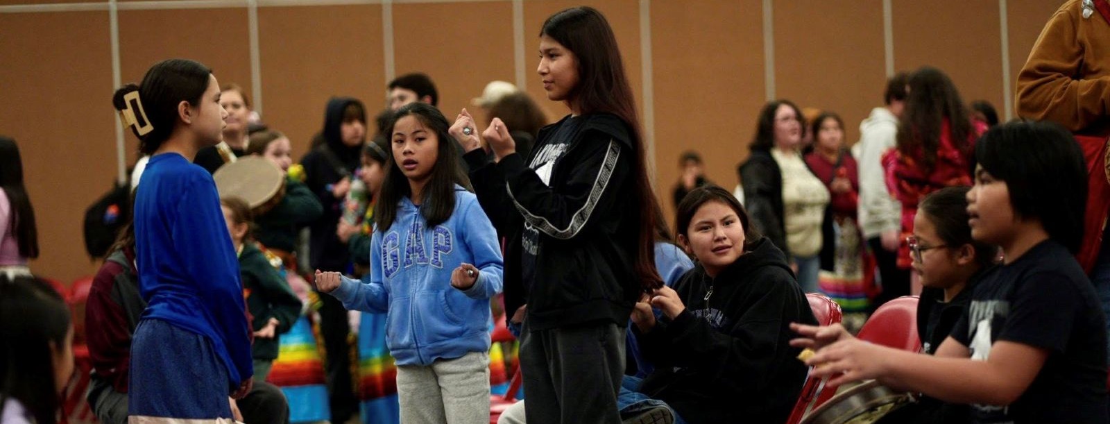 A group of students standing together, engaged in conversation and interaction.