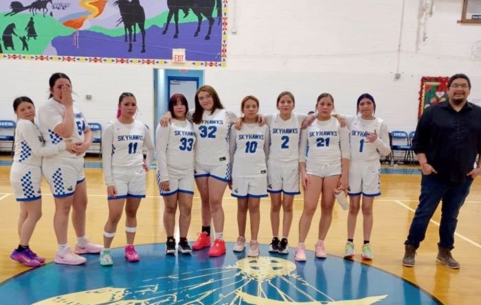 Girls basketball players smiling together during team recognition night.