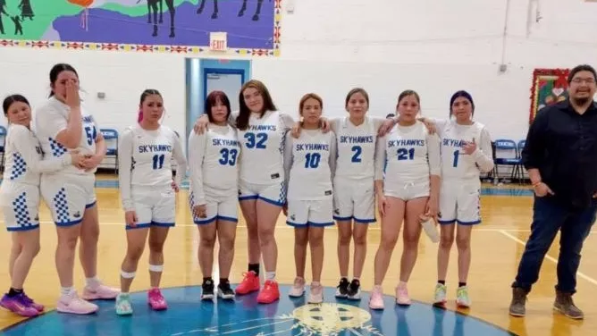 Girls basketball players smiling together during team recognition night.